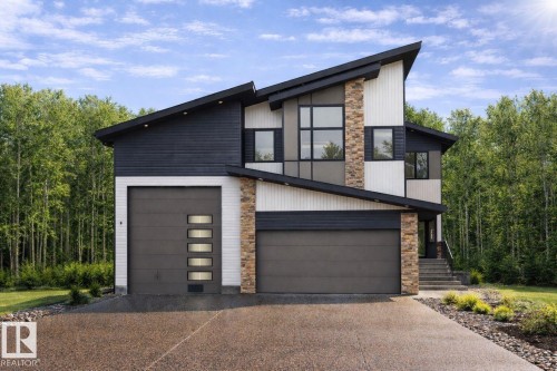 The property presents a striking modern exterior with a multi-textured facade featuring horizontal siding and stacked stone accents - 423 Robinson Boulevard, Leduc, AB - Outdoor