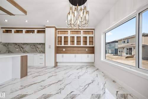 Expansive open-concept living area featuring a contemporary lighting fixture, large windows, and sleek marble-patterned flooring - 423 Robinson Boulevard, Leduc, AB - Indoor Photo Showing Other Room
