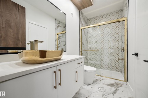 A bathroom featuring a vanity with a gold vessel sink, white countertop, and white cabinetry - 423 Robinson Boulevard, Leduc, AB - Indoor Photo Showing Bathroom