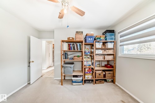 This room features light-colored walls and carpeting, a window with horizontal blinds, and a ceiling fan - 4446 116 Avenue, Edmonton, AB 