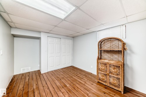 This room features wooden flooring, white bi-fold closet doors, and light-colored walls - 4446 116 Avenue, Edmonton, AB 