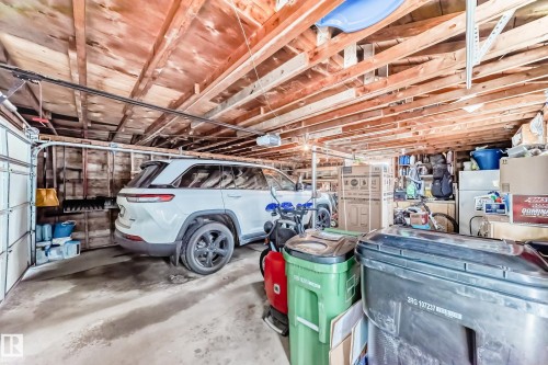 The property features a garage with exposed wood beam ceilings and a concrete floor - 4446 116 Avenue, Edmonton, AB 