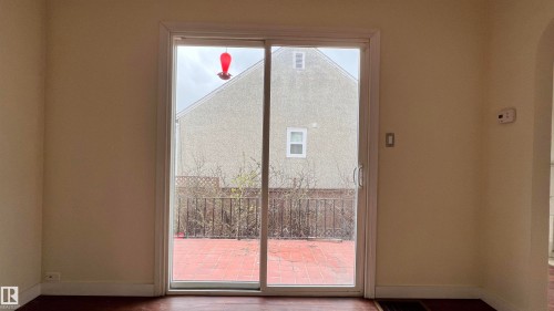 Sliding glass doors open to a private outdoor patio area - 10839 109 Street, Edmonton, AB - Indoor Photo Showing Other Room