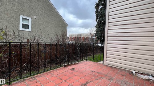 The property features a patio with terracotta tile flooring and a black wrought iron railing - 10839 109 Street, Edmonton, AB - Outdoor With Exterior