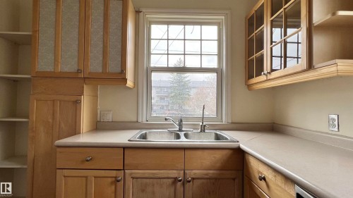 Kitchen featuring wood cabinetry, a double basin sink, and a window providing natural light - 10839 109 Street, Edmonton, AB - Indoor Photo Showing Kitchen With Double Sink