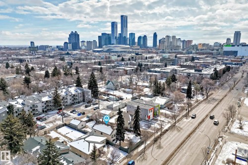 An aerial view showcasing the neighborhood with a clear view of the city skyline in the background, featuring numerous buildings and a stadium - 10839 109 Street, Edmonton, AB - Outdoor With View