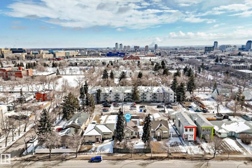 This aerial view showcases the property within a neighborhood featuring a mix of residential buildings and mature trees - 10839 109 Street, Edmonton, AB - Outdoor With View