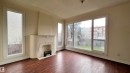 Living room featuring rich hardwood flooring, a decorative fireplace, and large windows providing natural light - 10839 109 Street, Edmonton, AB  - Indoor Photo Showing Other Room 