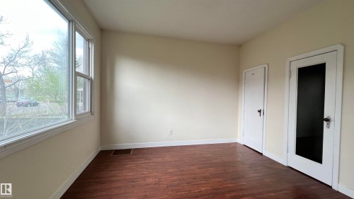 This room features rich wood flooring, neutral tone walls, and white trim - 10839 109 Street, Edmonton, AB - Indoor Photo Showing Other Room