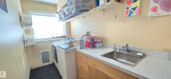This utility area includes a window, built-in shelving, a sink with a countertop, and cabinetry - 
