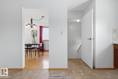 The property features a dining area with wood flooring and a chandelier, visible through an archway - 16108 100 Street, Edmonton, AB - Indoor Photo Showing Other Room