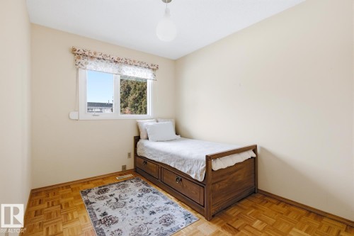 Bedroom featuring hardwood floors, a window with a valance, and a ceiling light fixture - 16108 100 Street, Edmonton, AB - Indoor Photo Showing Bedroom