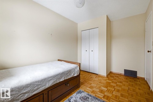 The room features hardwood floors and a white bi-fold closet - 16108 100 Street, Edmonton, AB - Indoor Photo Showing Bedroom