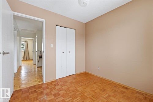 This room features light brown walls and parquet flooring - 16108 100 Street, Edmonton, AB - Indoor Photo Showing Other Room