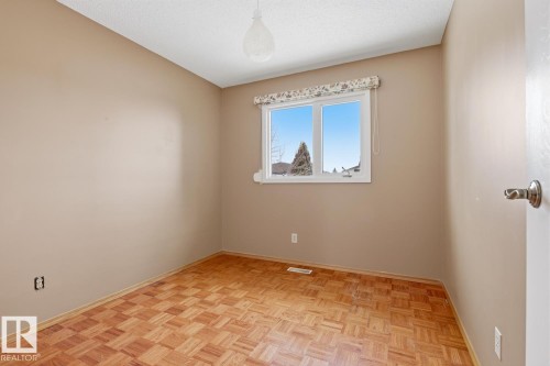 This room features light-colored walls and patterned wood flooring - 16108 100 Street, Edmonton, AB - Indoor Photo Showing Other Room