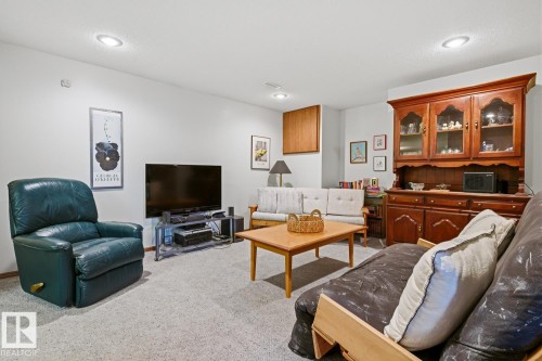 This inviting living space features light-colored carpeting and recessed lighting, creating a comfortable ambiance - 16108 100 Street, Edmonton, AB - Indoor Photo Showing Living Room