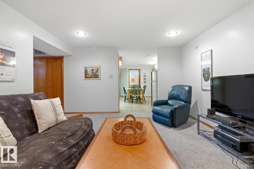 The living area features carpeted flooring and recessed lighting, with a view towards a dining area and kitchen beyond - 16108 100 Street, Edmonton, AB - Indoor Photo Showing Living Room