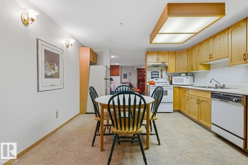 Kitchen featuring light wood cabinetry, a white dishwasher, and a white oven with an overhead microwave - 16108 100 Street, Edmonton, AB - Indoor