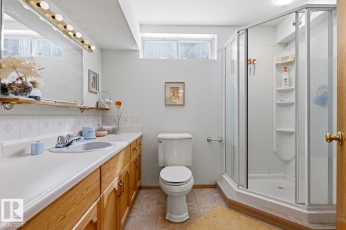 Bathroom with a wood vanity, white countertop, and a stand-up shower - 16108 100 Street, Edmonton, AB - Indoor Photo Showing Bathroom