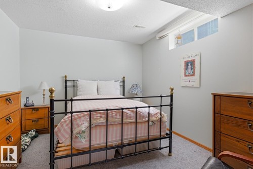 This room offers a comfortable atmosphere with light gray walls and gray carpeting - 16108 100 Street, Edmonton, AB - Indoor Photo Showing Bedroom