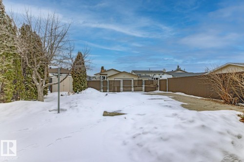 The property offers a spacious yard with a paved area and a detached garage, bordered by a chain link fence - 16108 100 Street, Edmonton, AB - Outdoor