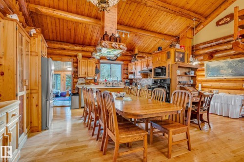 Expansive open-plan living area featuring a wood-paneled vaulted ceiling, exposed log walls, and light-toned hardwood flooring - 60017 Range Road 42, Rural Barrhead County, AB - Indoor Photo Showing Dining Room