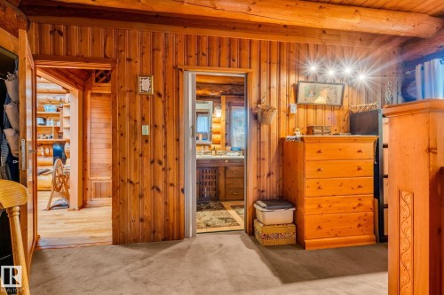 The interior features extensive wood paneling and exposed log beams - 60017 Range Road 42, Rural Barrhead County, AB - Indoor