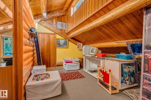 The property features exposed wooden log walls and ceiling beams, with a sloped wooden plank ceiling - 60017 Range Road 42, Rural Barrhead County, AB - Indoor Photo Showing Other Room