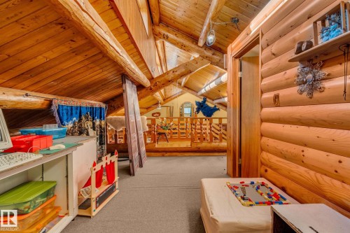 The property features natural wood log walls and exposed wooden beams, creating a rustic aesthetic - 60017 Range Road 42, Rural Barrhead County, AB - Indoor Photo Showing Other Room