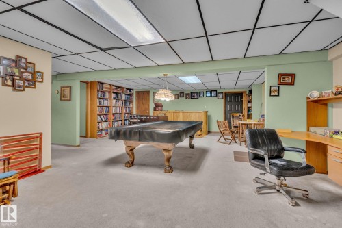 This spacious room features light green walls, a light-colored carpet, and a drop ceiling with integrated lighting - 60017 Range Road 42, Rural Barrhead County, AB - Indoor