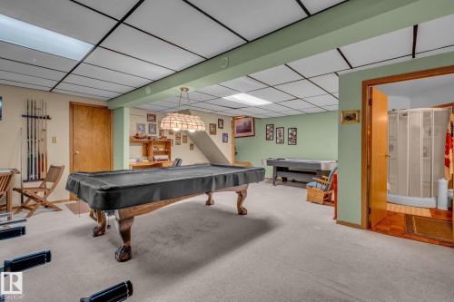 The property features a spacious room with light-colored carpeting, light green walls, and a drop ceiling with recessed lighting - 60017 Range Road 42, Rural Barrhead County, AB - Indoor Photo Showing Other Room