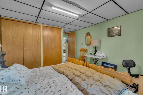Bedroom featuring light green walls, a light-colored wood bed frame, and two wood closets - 60017 Range Road 42, Rural Barrhead County, AB - Indoor Photo Showing Bedroom