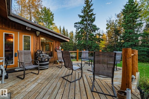 Spacious outdoor wood deck with natural wood siding and orange double doors - 60017 Range Road 42, Rural Barrhead County, AB - Outdoor With Deck Patio Veranda With Exterior