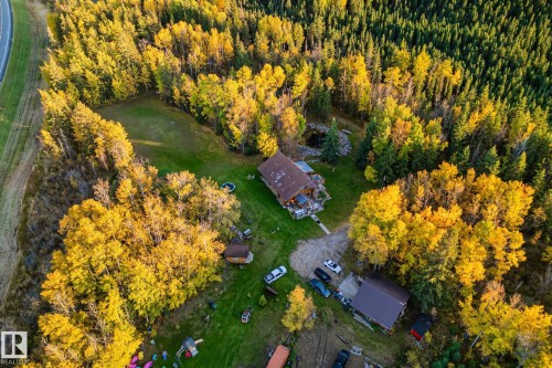 This property features a main residence with a brown roof and a separate outbuilding with a brown roof, all surrounded by extensive greenery - 60017 Range Road 42, Rural Barrhead County, AB - Outdoor With View