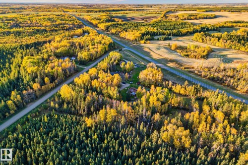 The property is surrounded by dense woodlands featuring both evergreen and deciduous trees - 60017 Range Road 42, Rural Barrhead County, AB - Outdoor With View