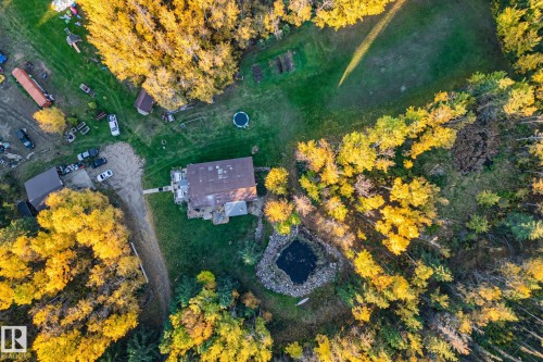 The property features a residence surrounded by extensive green areas and mature trees - 60017 Range Road 42, Rural Barrhead County, AB - Outdoor With View