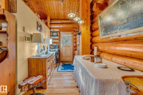 This interior space features exposed log walls and a wooden ceiling, creating a warm aesthetic - 60017 Range Road 42, Rural Barrhead County, AB - Indoor Photo Showing Other Room