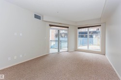 This open living area features neutral-toned carpeting and light-colored walls, creating a bright and inviting atmosphere - 