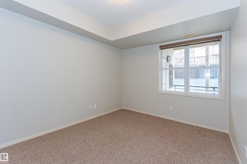 This room features neutral-toned carpet, light-colored walls, and a window with blinds providing natural light - 415 10503 98 Avenue, Edmonton, AB - Indoor Photo Showing Other Room