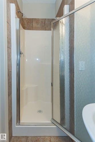 Bathroom featuring a stand-up shower with a showerhead and a sliding door - 415 10503 98 Avenue, Edmonton, AB - Indoor Photo Showing Bathroom