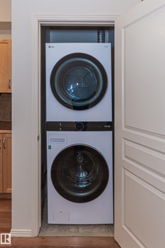 Laundry closet featuring a stacked white washer and dryer unit - 415 10503 98 Avenue, Edmonton, AB - Indoor Photo Showing Laundry Room