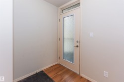 Entryway featuring hardwood floors and a door with frosted glass and a transom window - 