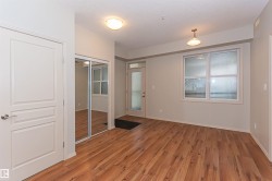Entryway featuring wood-style flooring, a mirrored closet, and a white door with a silver handle - 