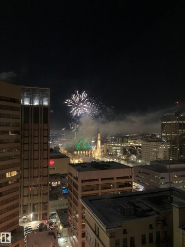 Enjoy elevated city views from the property, featuring a visible fireworks display, illuminated downtown buildings, and a distinctive green-domed structure - 1701 10024 Jasper Avenue, Edmonton, AB - 