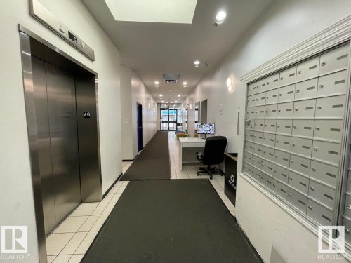 The property features a well-maintained hallway with tiled flooring and recessed lighting, providing access to an elevator - 1701 10024 Jasper Avenue, Edmonton, AB - Indoor Photo Showing Other Room