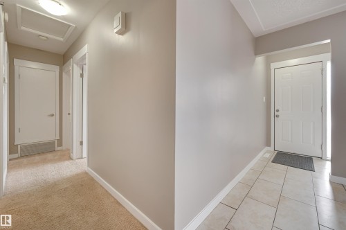 The entrance features light-colored tile flooring, leading to a hallway with carpeting - 13211 104 Street, Edmonton, AB - Indoor Photo Showing Other Room