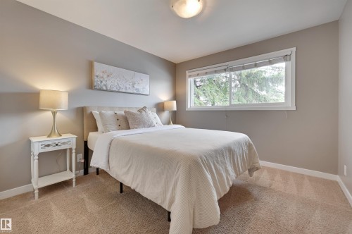 This room features a window providing natural light, neutral wall paint, and carpet flooring - 13211 104 Street, Edmonton, AB - Indoor Photo Showing Bedroom