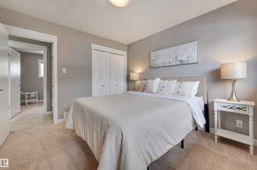 This room features a soft carpeted floor, light grey walls, and a white bi-fold closet - 13211 104 Street, Edmonton, AB - Indoor Photo Showing Bedroom