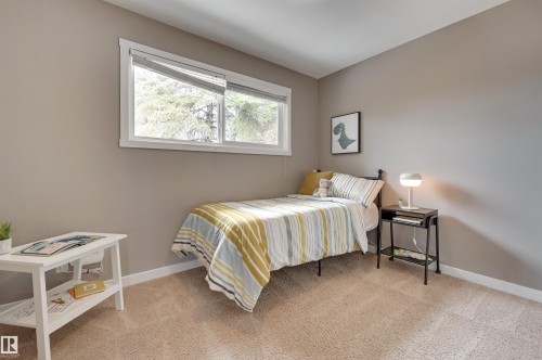 This room features a window providing natural light, neutral-toned walls, and carpeted flooring - 13211 104 Street, Edmonton, AB - Indoor Photo Showing Bedroom