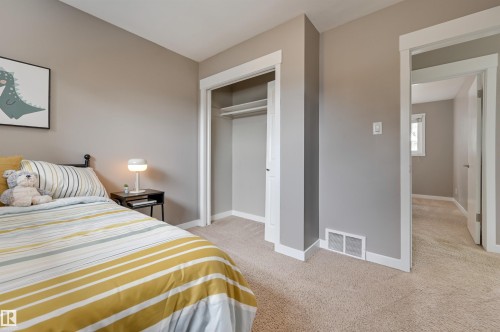 This room features carpeted flooring, a closet with an open doorway, and a neutral wall color - 13211 104 Street, Edmonton, AB - Indoor Photo Showing Bedroom
